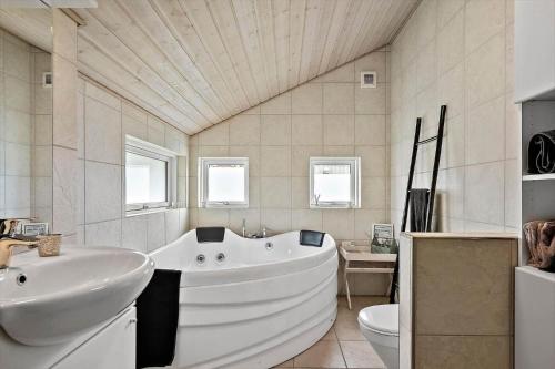 a large white bathroom with a tub and a toilet at 358-Hvide-Sande-Fyrmarken-25 in Hvide Sande