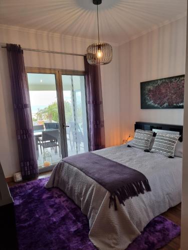 a bedroom with a large bed with a purple rug at Sol e Luna in Ponta