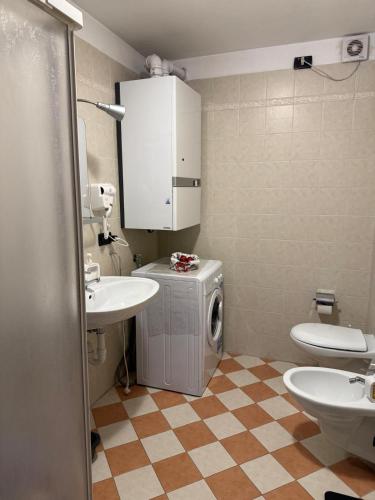 a bathroom with a sink and a washer and dryer at Max 's Siusi Apartament in Siusi
