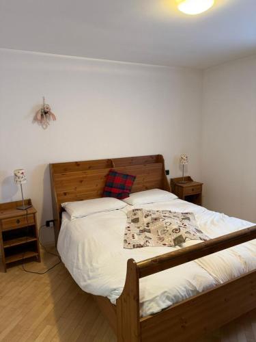 a bedroom with a large bed with a wooden headboard at Max 's Siusi Apartament in Siusi