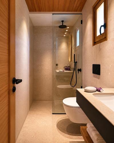 a bathroom with a toilet and a glass shower at Mili Resort in Polychrono