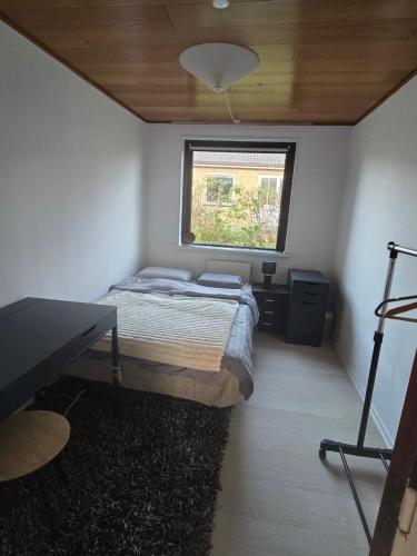 a small bedroom with a bed and a window at Small and cozy room in Kalundborg