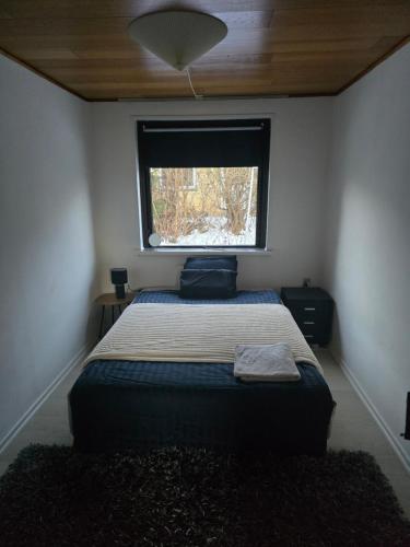 a small bedroom with a bed with a window at Small and cozy room in Kalundborg