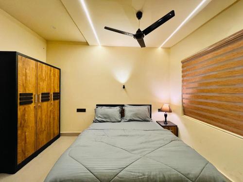 a bedroom with a bed and a ceiling fan at SJ Homes in Karukachal