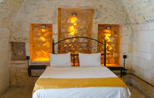 a bedroom with a bed in a stone wall at Hızmalı OTEL in Urfa