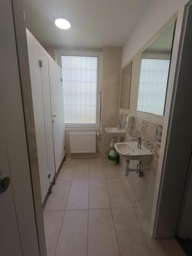 a large bathroom with two sinks and a window at Youth Hostel Podlasie in Białystok