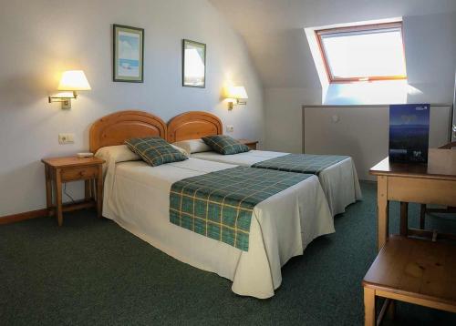 a hotel room with a large bed and a window at Hotel Spa Bosque Mar in Reboredo