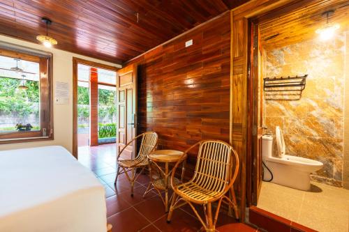 a bedroom with a bed and two chairs and a sink at Mango Village in Phú Quốc