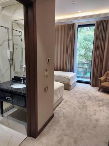 a hotel room with a bathroom with a sink and a bed at Chorchaman Hills in Patkunob