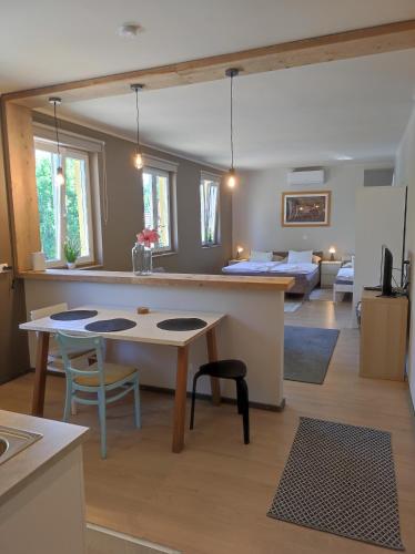 a kitchen and living room with a table and a couch at Deák Houses in Nagykőrös