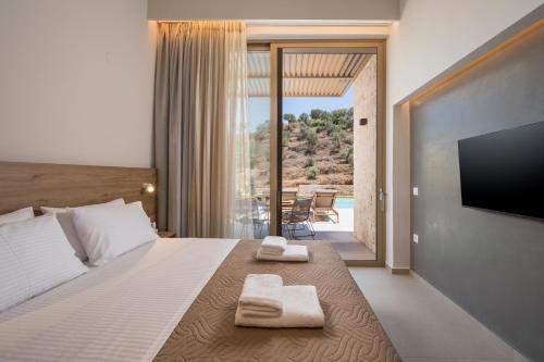 a bedroom with a bed with two towels on it at La Divina Luxury Villas with Heated Pool in Daratso