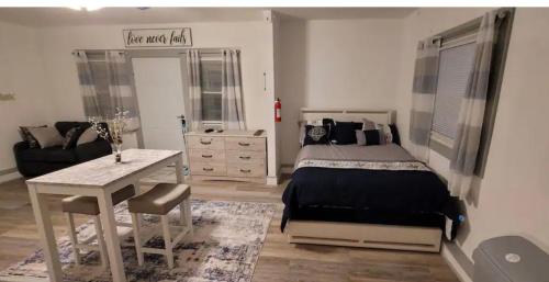 a bedroom with a bed and a table and a couch at The Cottage in Dagsboro
