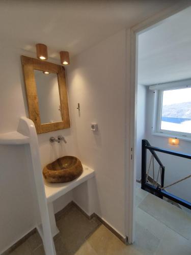 a bathroom with a wooden sink and a mirror at Caldera Serenity - Small Luxury Villas in Imerovigli
