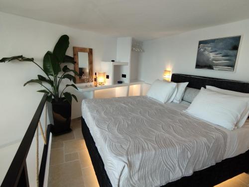 a bedroom with a bed and a potted plant at Caldera Serenity - Small Luxury Villas in Imerovigli