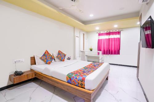 a bedroom with a large bed in a room at FabHotel Aarvi Inn in Aurangabad