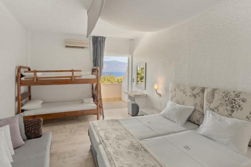 a bedroom with two beds and a bunk bed at Long Beach Hotel & Resort in Lóngos