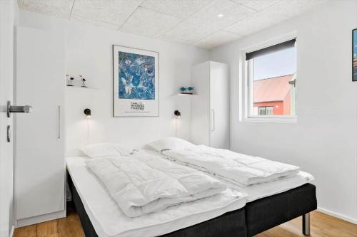 a white bedroom with a large bed with white sheets at 945-Hvide-Sande-Langsand-163 in Hvide Sande