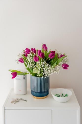 a blue vase with purple flowers on a white cabinet at La Stazione Formia in Formia
