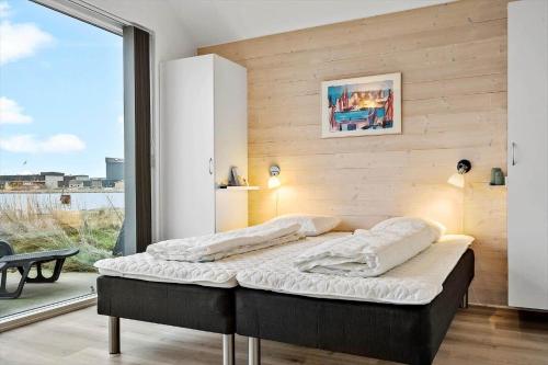 a large bed in a room with a large window at 704-Hvide-Sande-Slusen-4 in Hvide Sande