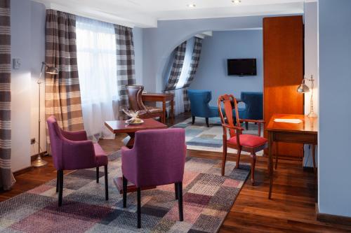 - un salon avec des chaises violettes et une table dans l'établissement Hotel Rejs, à Ustka