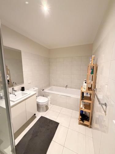 a bathroom with a tub and a toilet and a sink at Shared House in Melbourne in Bundoora
