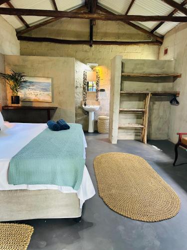 a bedroom with a bed and a staircase and a sink at Emoyeni Eco Lodge in Sodwana Bay