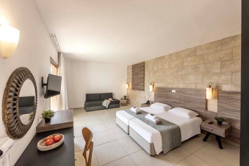 a bedroom with a bed and a living room at Electra Beach Holiday Village in Ayia Napa