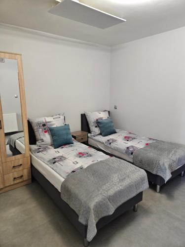 ein Schlafzimmer mit zwei Betten und einem Spiegel in der Unterkunft Hostel 405 in Polanka Wielka
