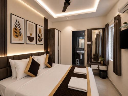 a bedroom with a bed with white sheets and pillows at Sri Padmavati Pleasants in Palni