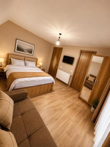 a bedroom with a bed and a couch and a television at Wonder Hill group in Bakuriani