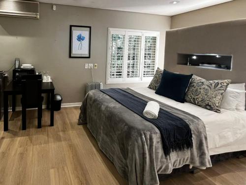 a bedroom with a bed and a desk and a computer at Athlone Lodge in Pietermaritzburg