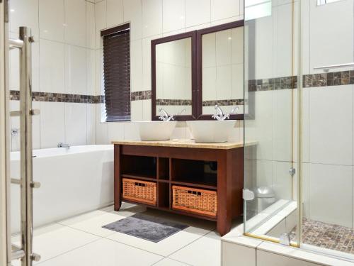 a bathroom with two sinks and a tub at Athlone Lodge in Pietermaritzburg