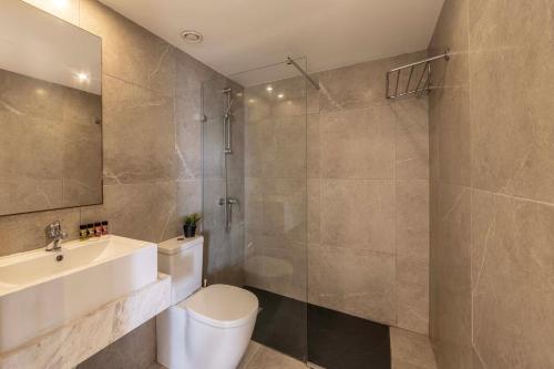 a bathroom with a toilet and a sink and a shower at Electra Beach Holiday Village in Ayia Napa