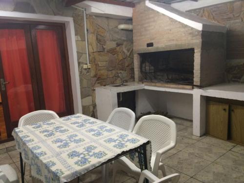 uma mesa e cadeiras numa cozinha com lareira em Casa Cami seña para confirmar reserva em Piriápolis