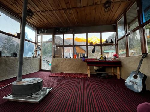 a room with a stove and a guitar in it at EcoGlampLife in Kalgha