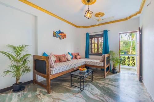 a living room with a couch and a tv at The Sequeira Goa in Majorda