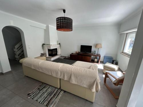 a bedroom with a large bed and a living room at Sal Guest House in Costa da Caparica