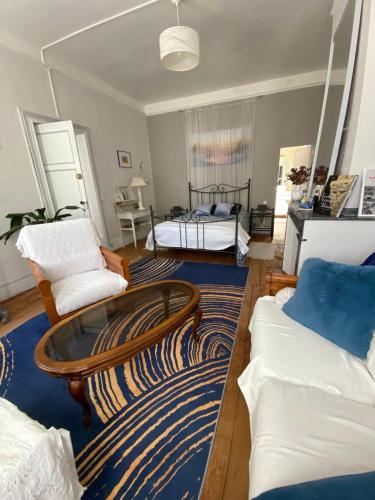 a living room with two beds and a coffee table at Au Jardin in Moissac