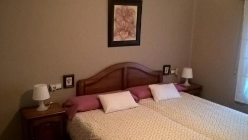 una camera con un letto con due cuscini sopra di Apartamento Cabañal a Cullera