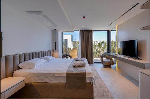 a bedroom with a large bed and a flat screen tv at VENTO MARE Çeşme in Çeşme