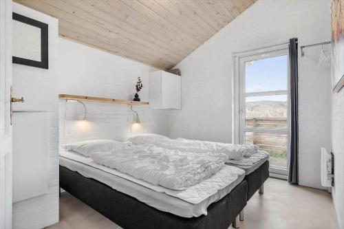 a large bed in a room with a window at 461-Hvide-Sande-Tingodden-152 in Hvide Sande