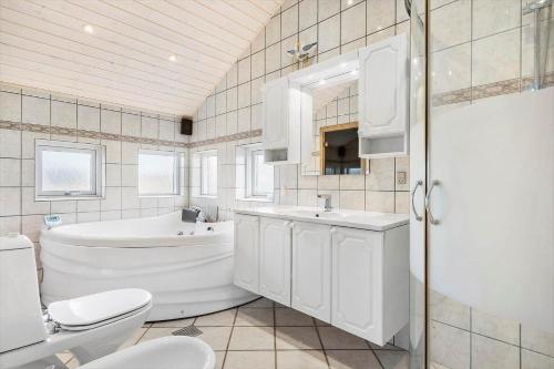 a bathroom with a tub and a toilet and a sink at 461-Hvide-Sande-Tingodden-152 in Hvide Sande