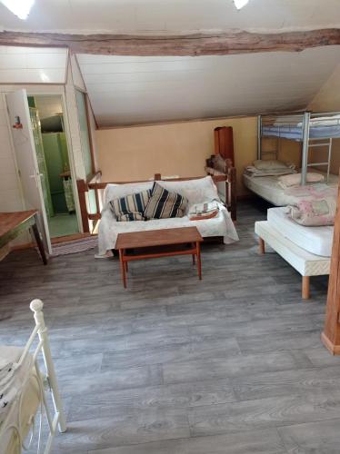 a living room with two beds and a table at Gîte rustique en Morvan in Brassy