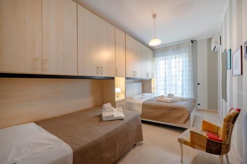 a bedroom with two beds and a chair and a window at Damè in Conversano