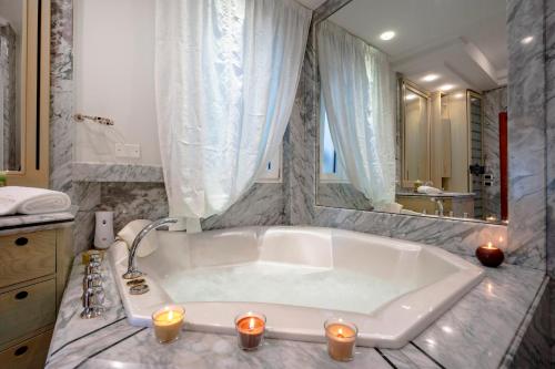 a bathroom with a large tub with candles in it at Damè in Conversano