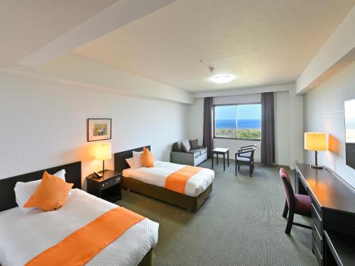 a hotel room with two beds and a desk at Livemax Resort Hakodate Shikabe Onsen in Shikabe