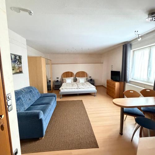a living room with a blue couch and a bed at Winzerhaus St Joseph in Piesport