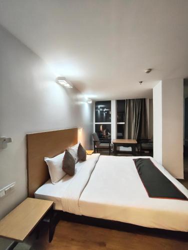 a bedroom with a large bed and a living room at GH Brother Eureka in Guwahati