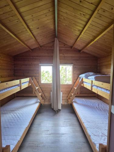 a room with two bunk beds in a wooden cabin at Stuga 21 i Dalskärs Camping in Bergkvara