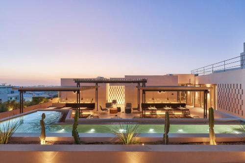 a house with a swimming pool in front of a building at Enorme EOS Santorini - Adults Only in Pyrgos